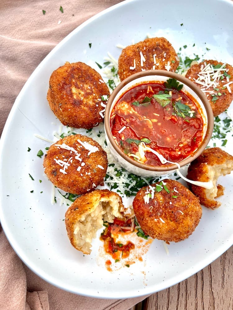 Arancini (Cheesy Fried Risotto Balls) in a plate with marinara sauce