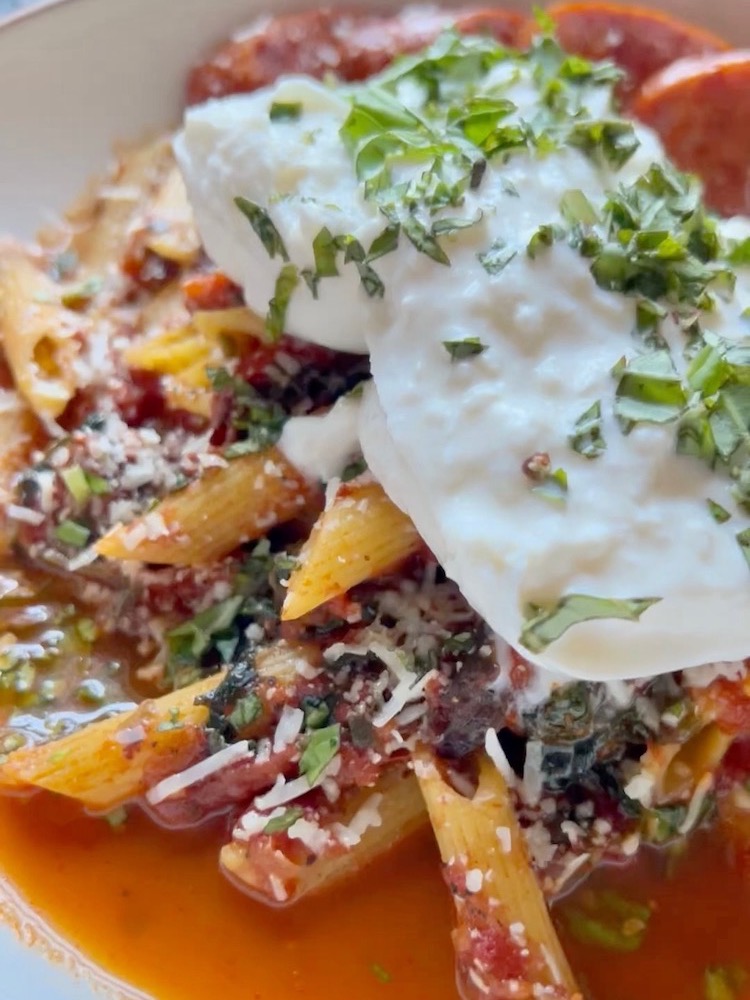 Penne Marinara with sausage and burrata cheese on a plate
