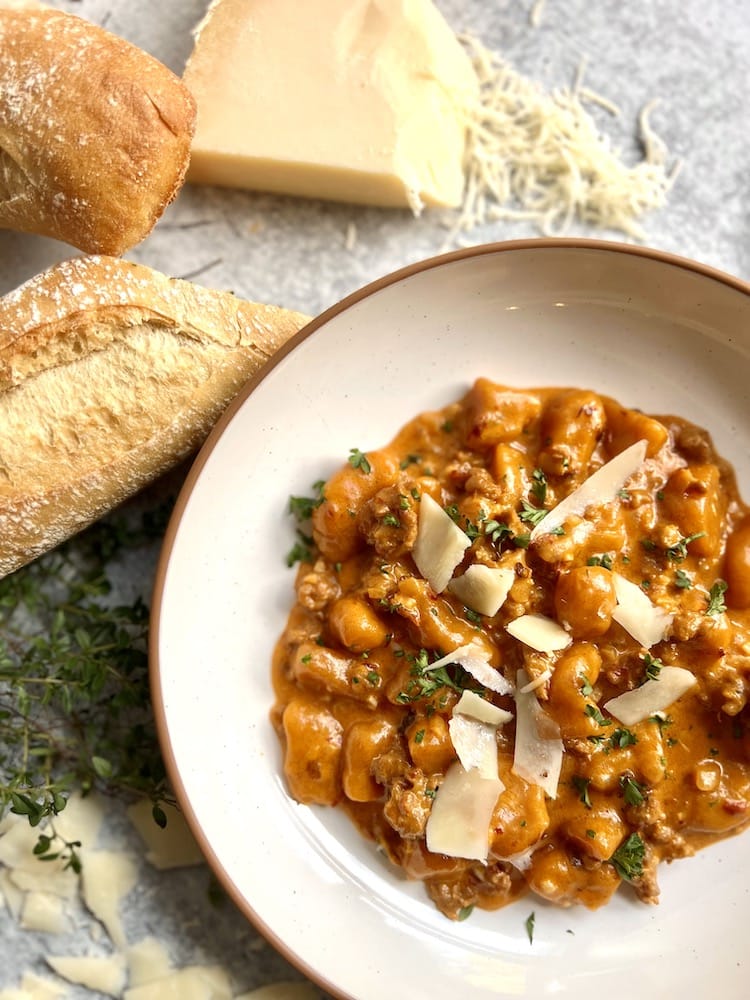 Sweet Potato Gnocchi with Chipotle Cream Sauce on a plate beside some bread slices