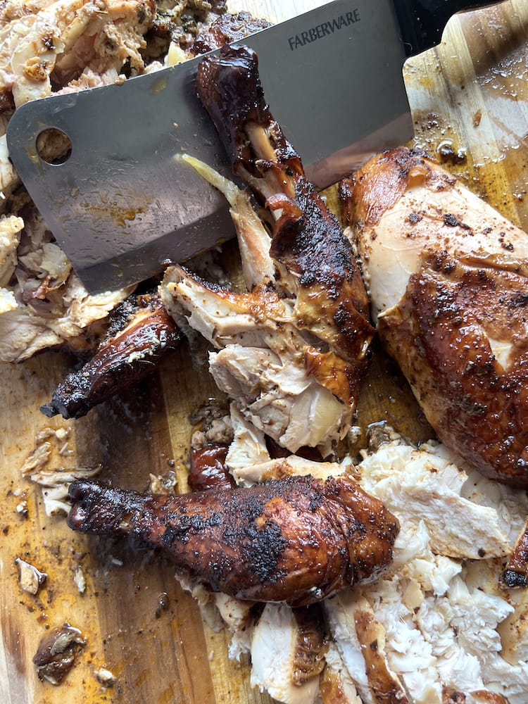 BBQ Smoked Chicken on a wooden cutting board with butcher knife