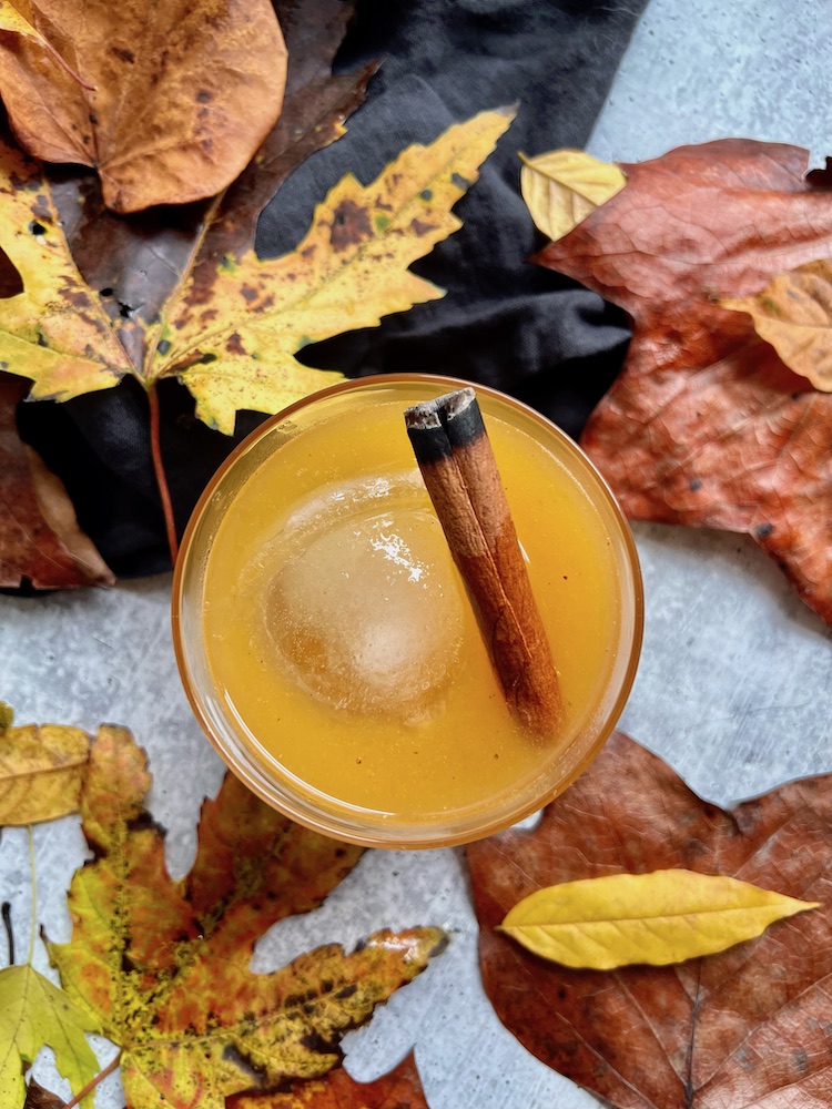 Bonfire Bourbon Peach Cocktail surrounded by leaves