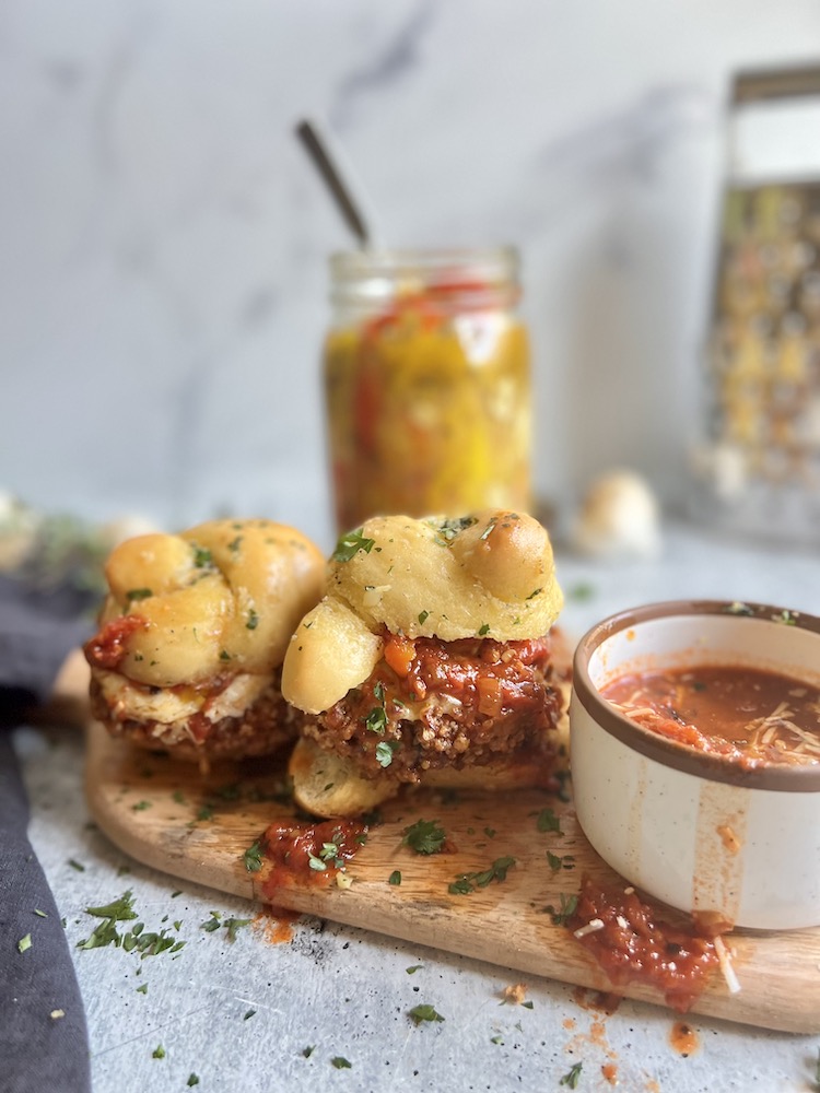 Chicken Parm Sliders with ramekin of marinara sauce and jar of Italian peppers
