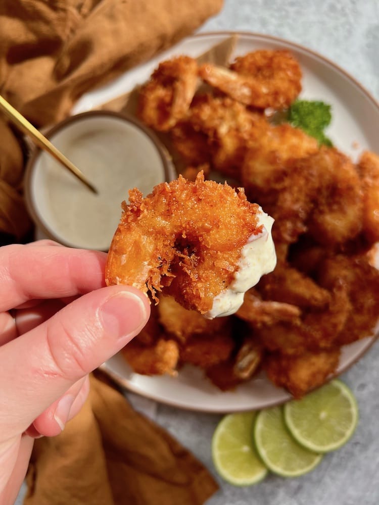 Coconut Fried Shrimp with Curry Dipping Sauce held in a hand