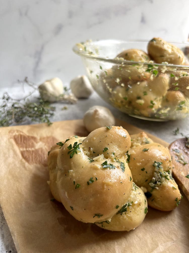 Homemade Garlic Knots on parchment paper and in bowl