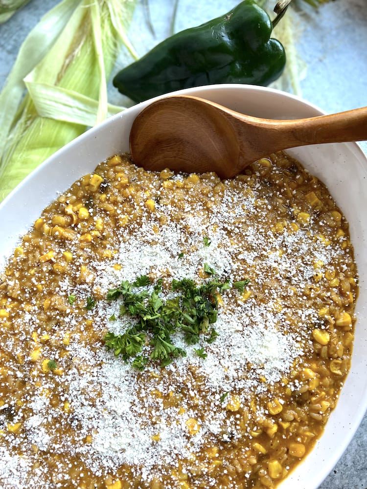Poblano Corn Risotto in a serving dish topped with Cotija cheese and fresh parsley