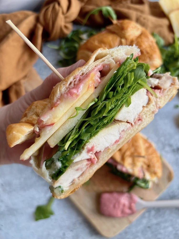 Turkey Cranberry Sandwich held in a hand showing all of the layers of ingredients