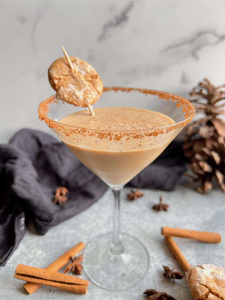 Eggnog Martini in a cinnamon sugar rimmed glass garnished with a speared chai cookie