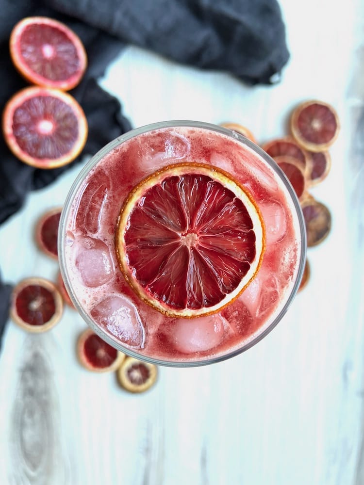 Overhead shot of a Non-Alcoholic Aperol Spritz in a wine glass with a dried orange slice