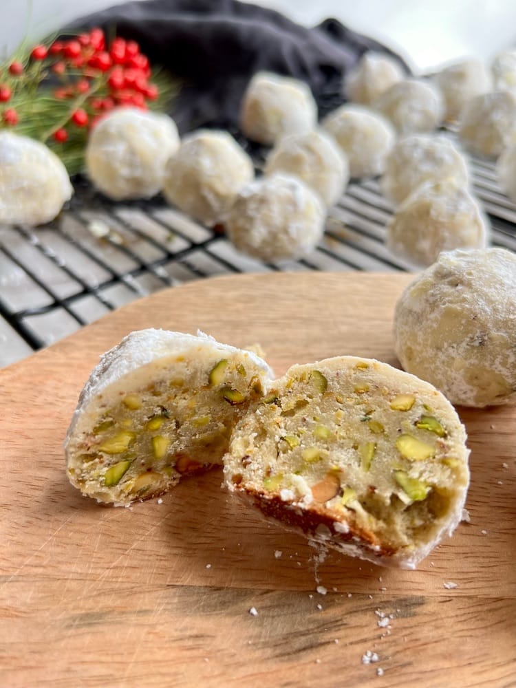 Pistachio Snowball Cookies with one cookie cut in half to see the inside