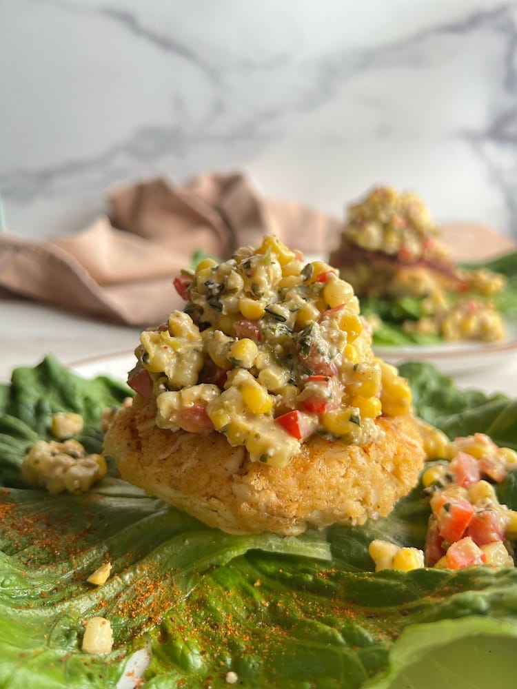 Two Street Corn Topped Crab Cakes served on large romaine lettuce leaves