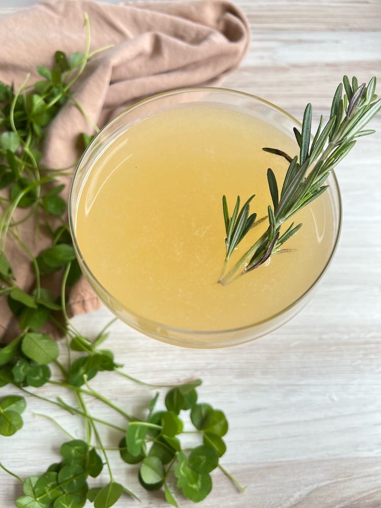 The Lucky Pear Cocktail in a coupe glass with rosemary sprig
