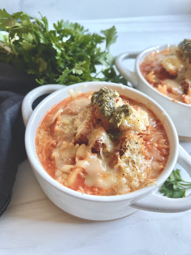 Chicken Parmesan Soup in two bowls with fresh parsley in the background