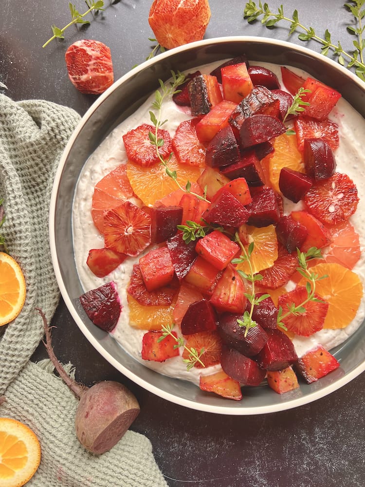 Beet and Citrus Salad with Spiced Yogurt in a serving dish surrounded by fresh pieces of citrus