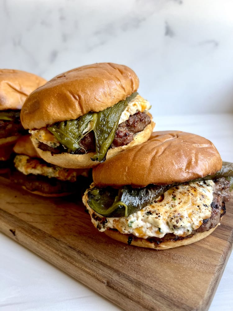 Poblano Popper Burger set on a wooden cutting board with white background