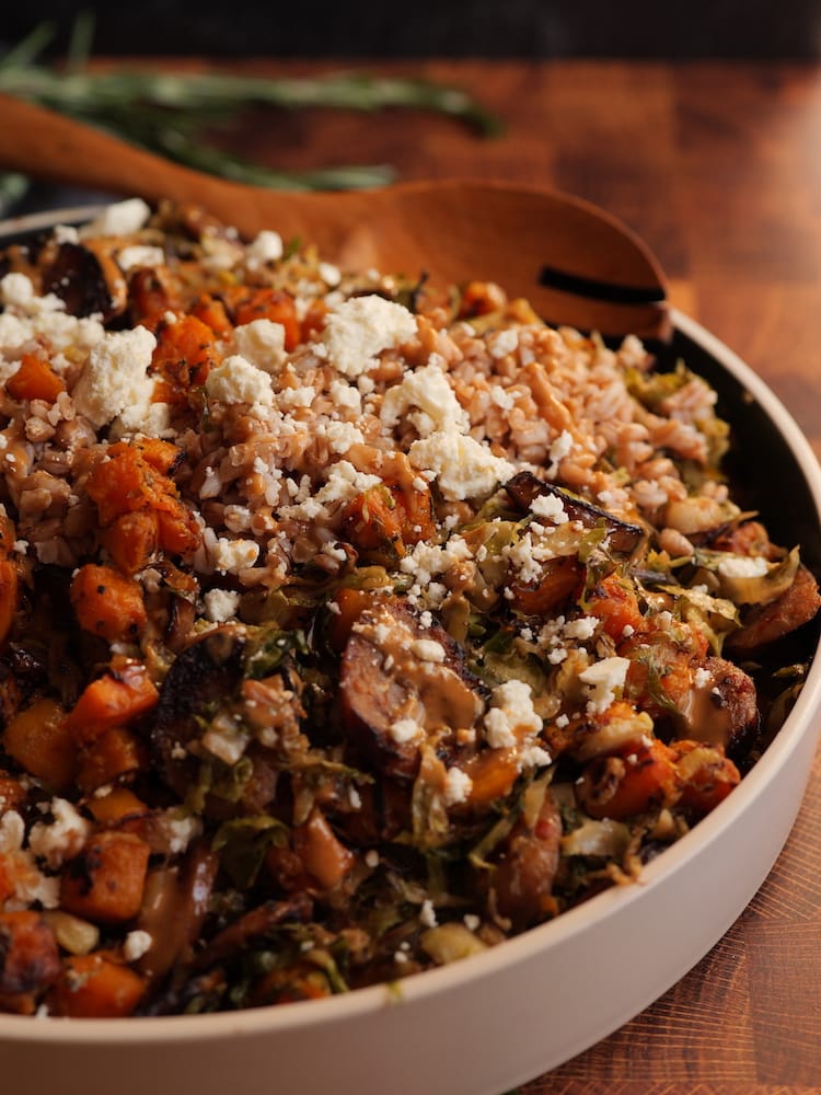 Sausage, Squash & Sprouts Bowl in a large serving dish with wooden serving spoon resting on edge of dish