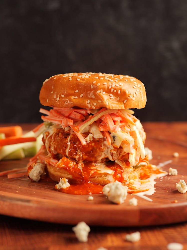 One of our Buffalo Chicken Burgers on a wooden serving board