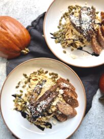 Pumpkin Pasta with Rosemary Cream Sauce on two plates with sausage and mushroom